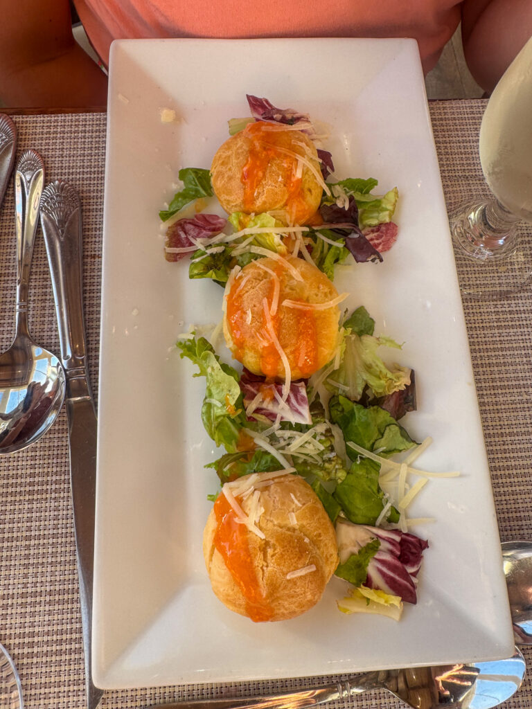 Three small plated starters set along a rectangular dish