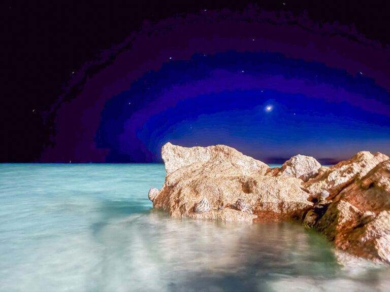 The cove lit from below after dark, the rock standing black against it