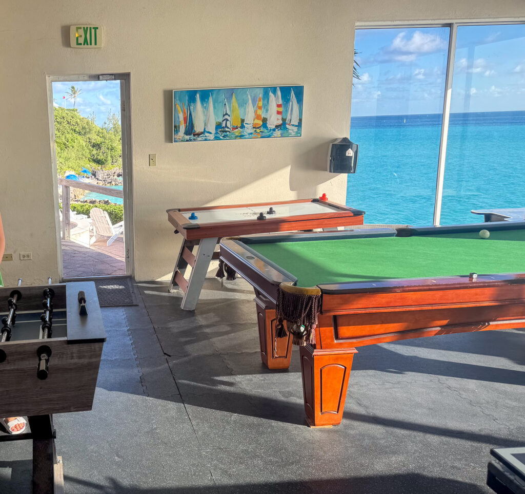 A pool table in the same room, the water bright through the glass