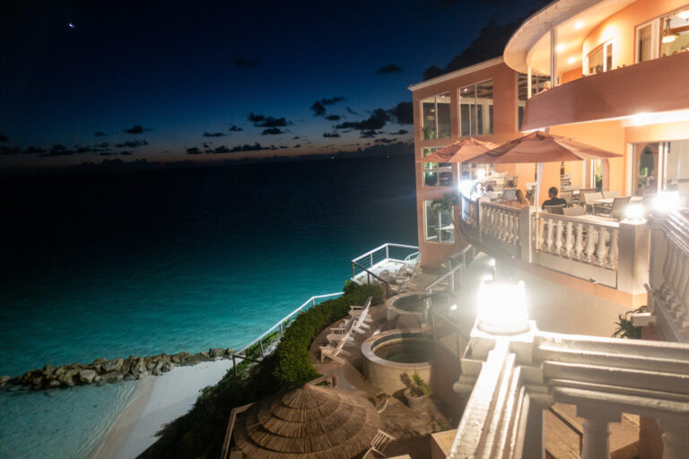The lit buildings along the bluff above the dark beach