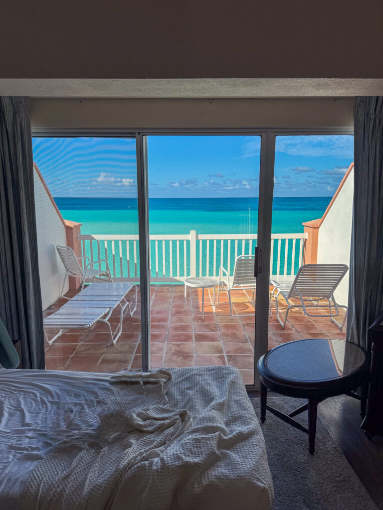 A room with the doors open onto the balcony and the water