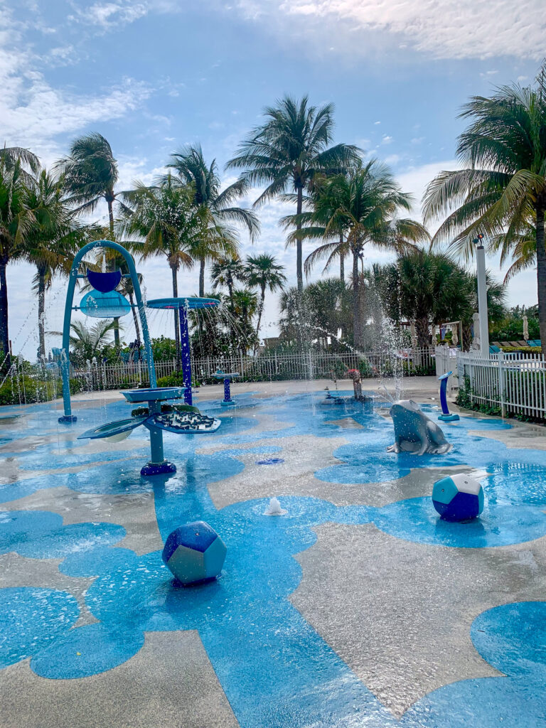 The splash pool from the far side, the water very blue against the deck