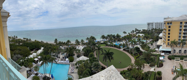 A wide look across the pools and lawns to the water