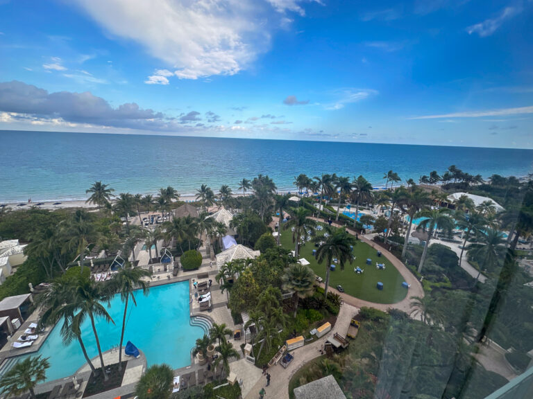 Pools, lawns and palms laid out between the building and the beach