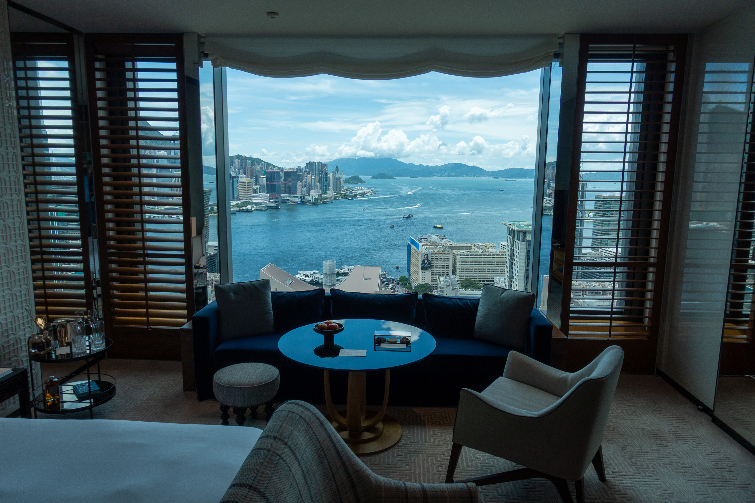 A round blue table at the window with the harbour spread out behind