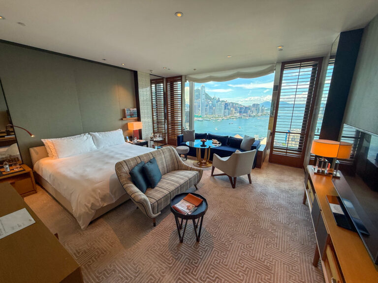The full width of the room, bed and seating, the harbour along one side