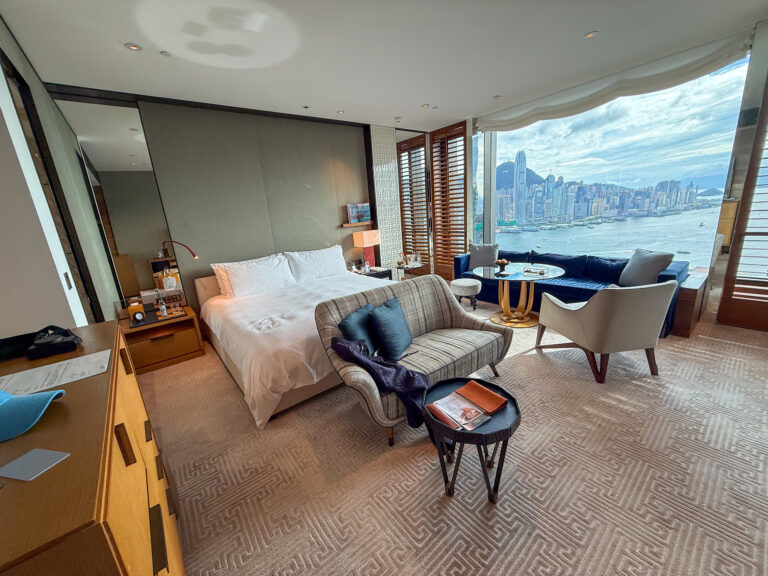 The bedroom and seating in flat daylight, shutters folded back
