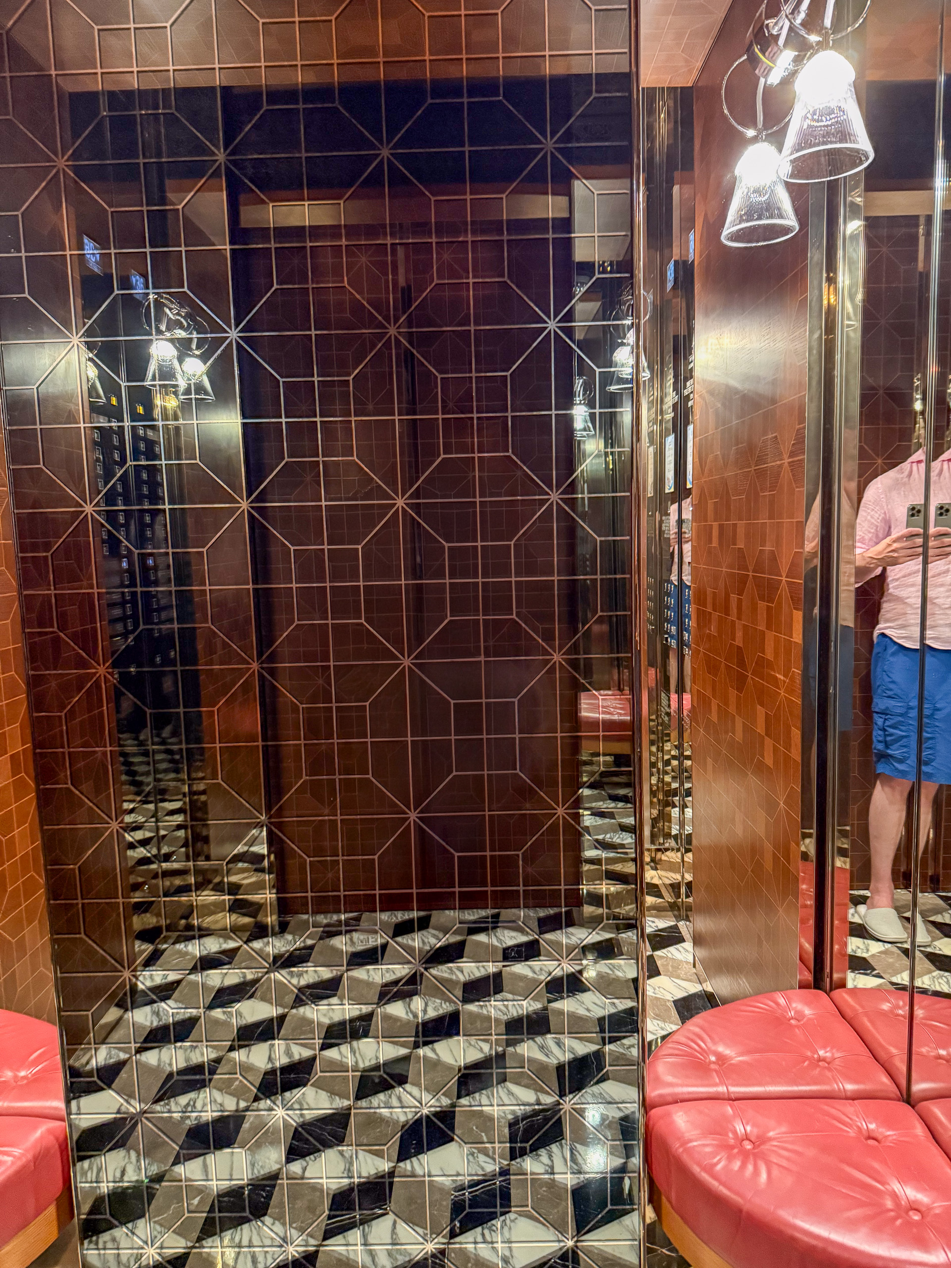 A tiled lobby with a chequerboard floor and mirrored doors
