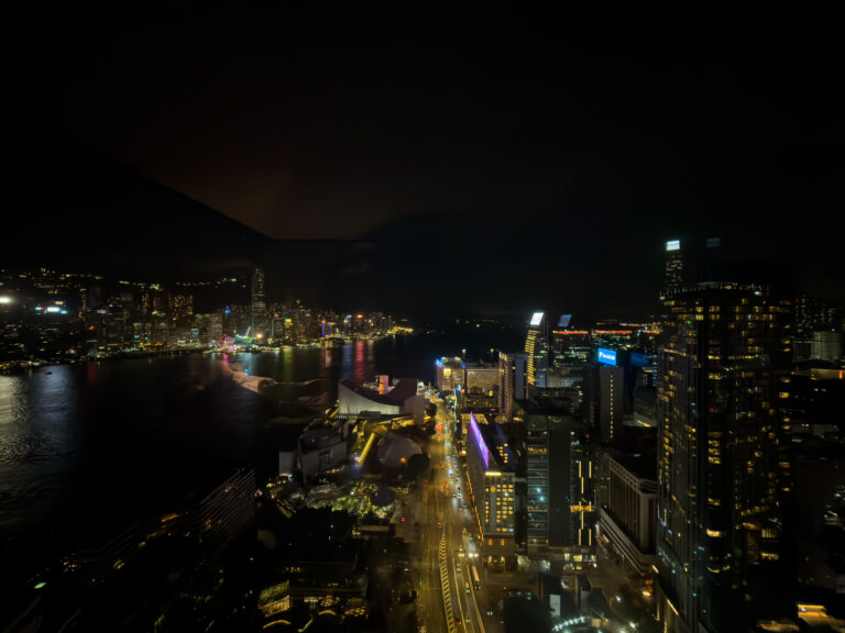 The city and harbour after dark from high up, traffic threading below