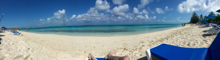 A panorama of the bay from a sun lounger, the water shelving from white to blue