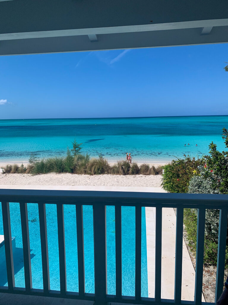 The beach and reef seen over a blue balcony rail