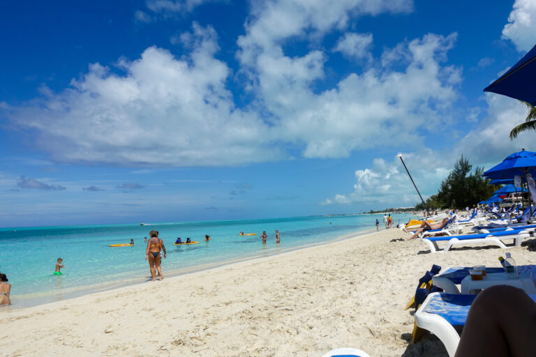 Swimmers, kayaks and parasols along a busy stretch of beach