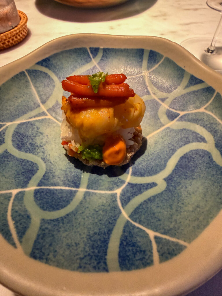 A single composed course in a blue-glazed bowl