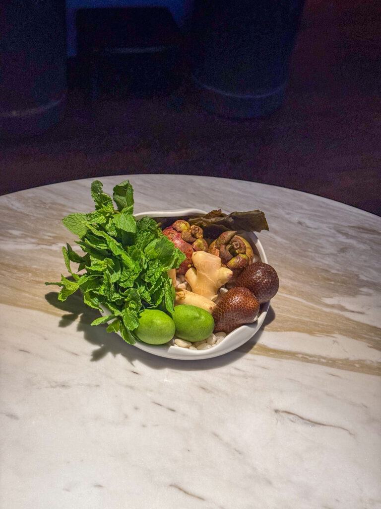 Herbs, greens and shellfish arranged on a shallow plate