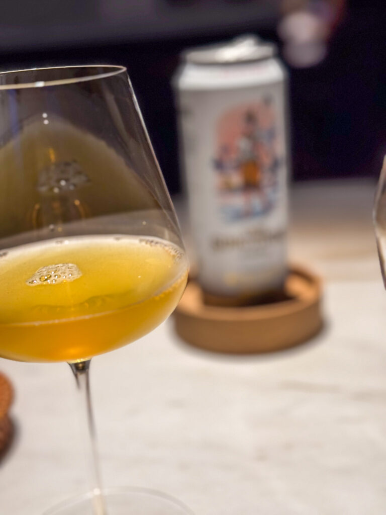 A cold beer poured beside the plate