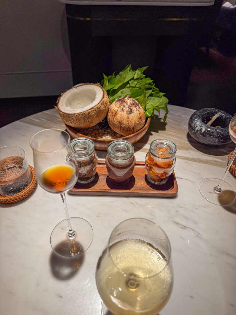 Small jars and a coconut set out on a wooden board