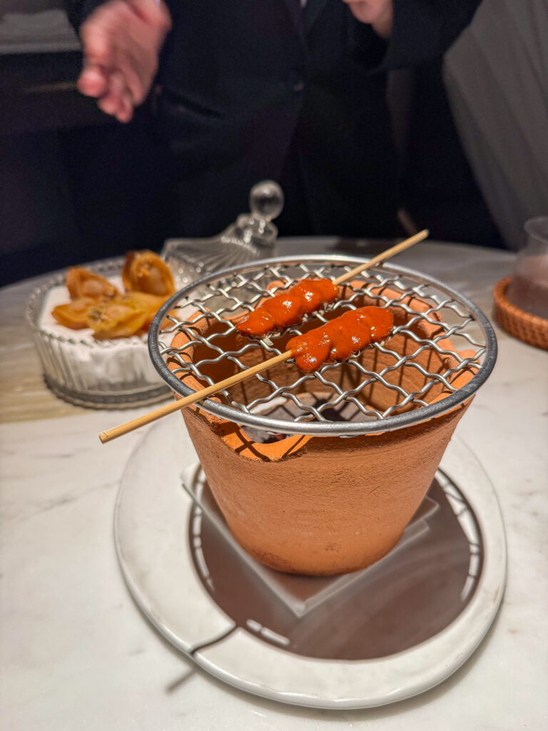 A grilled course served over a terracotta pot