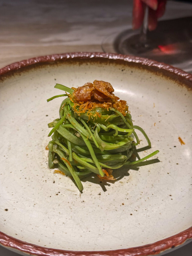 Beans nested on the plate under a spoonful of relish