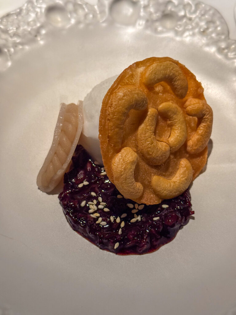 A crisp golden ring set on a dark purée