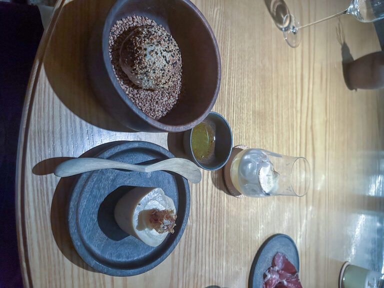 Small dishes and a cocoa-dusted bite set in stone bowls on the table