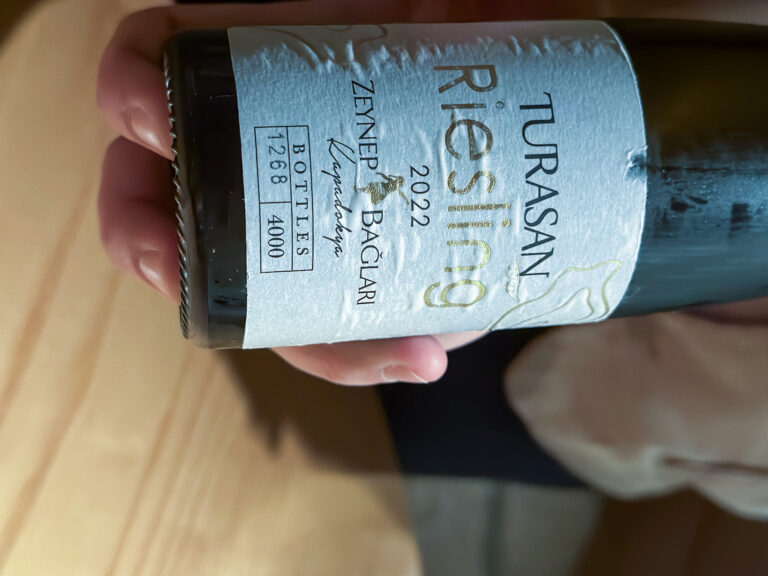A bottle of Turasan riesling held out, the vintage showing