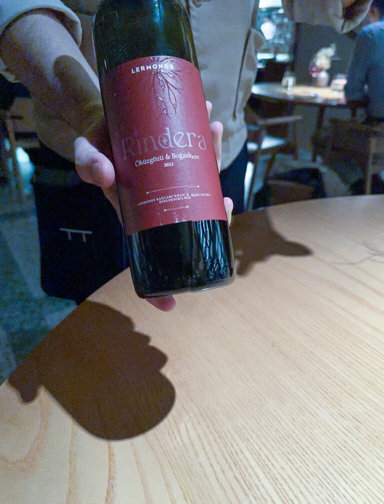 A bottle of Rindera held up in the dining room