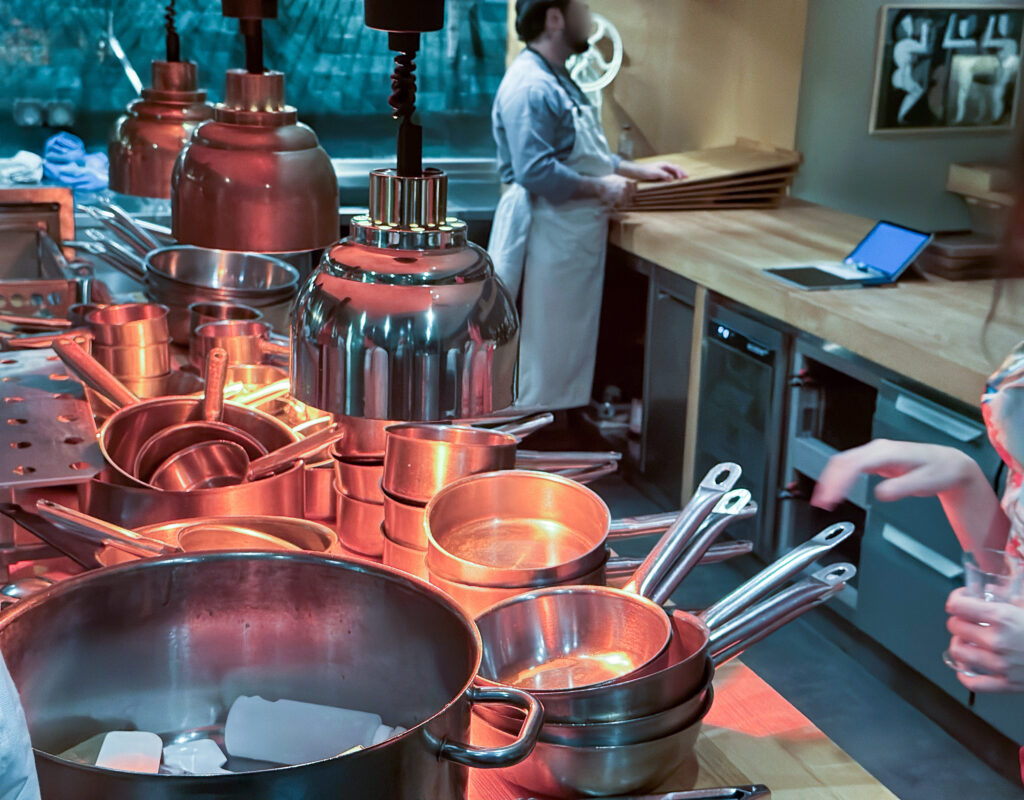 Copper pans hanging under red light above the range