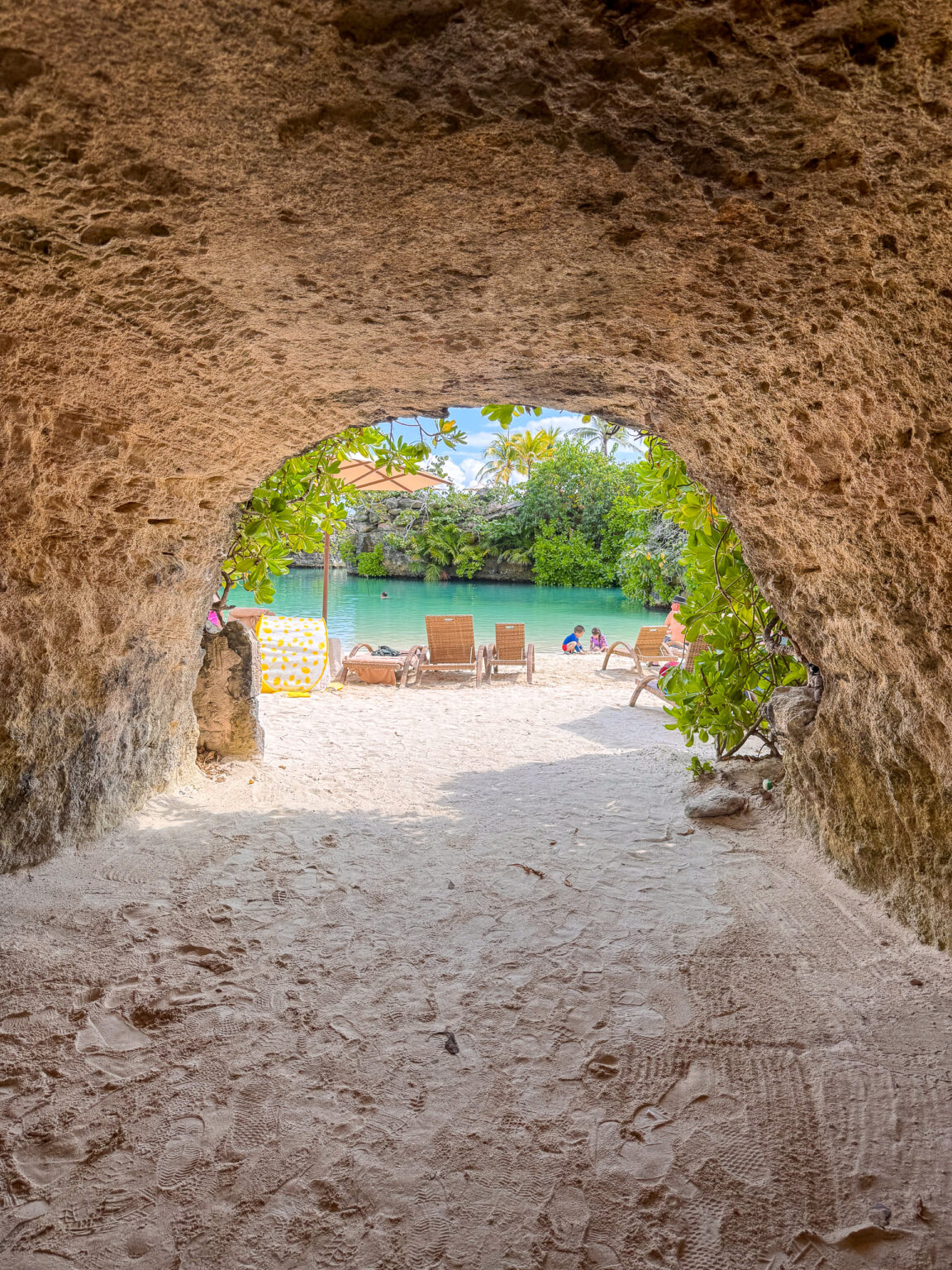A cut passage through the limestone opening onto blue water