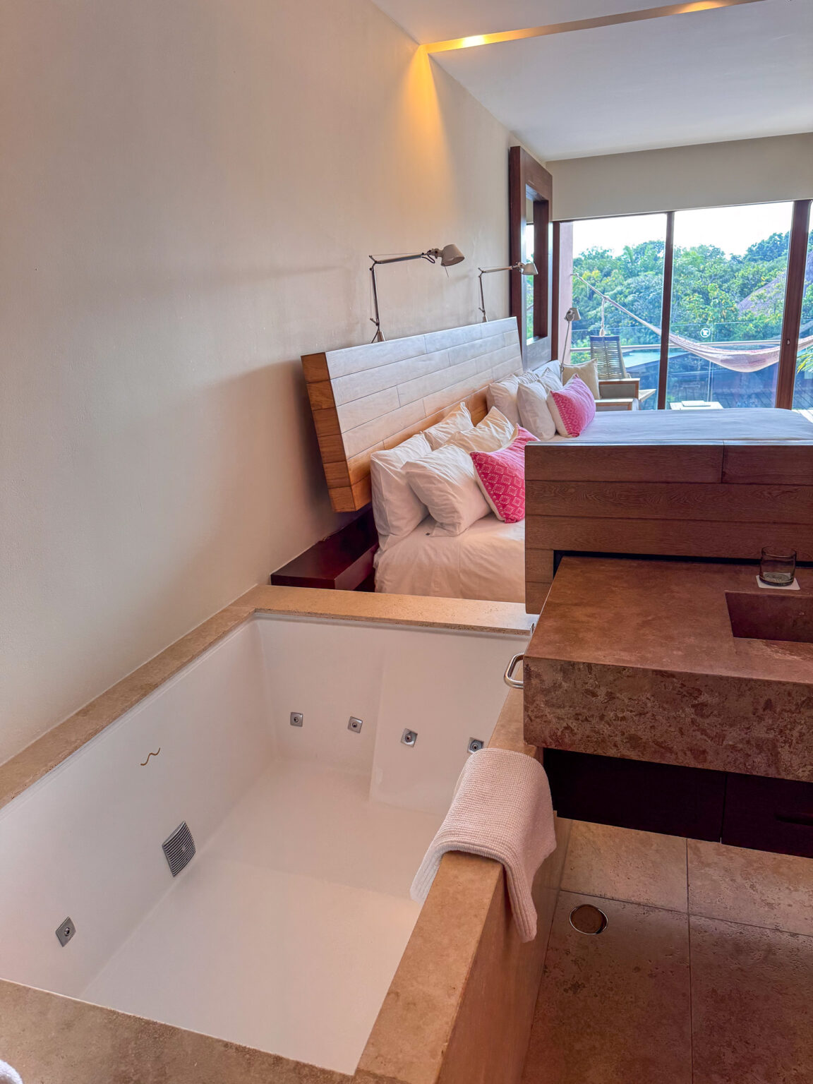 A deep tub set below the window, the light coming in behind it