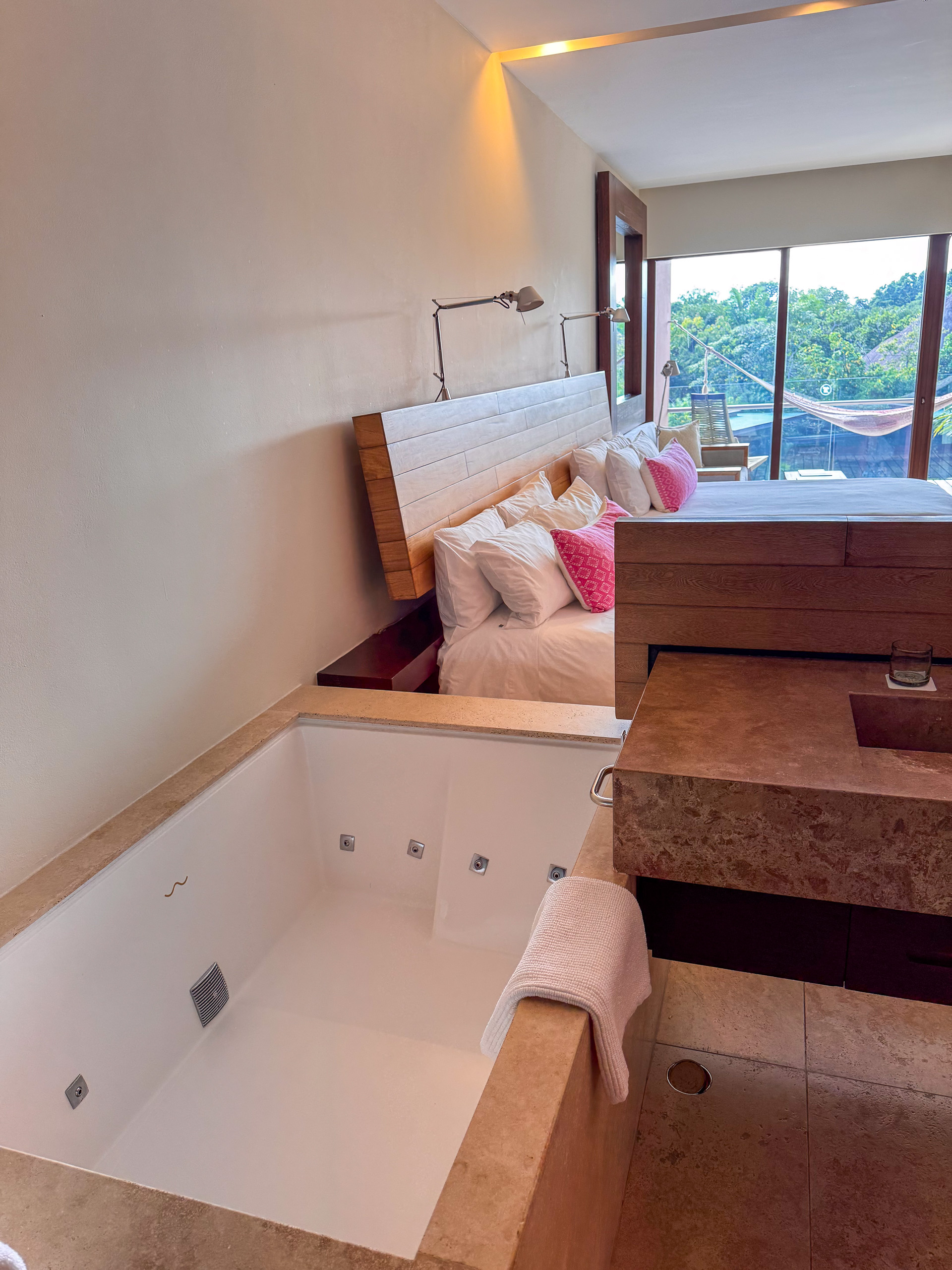 A deep tub set below the window, the light coming in behind it
