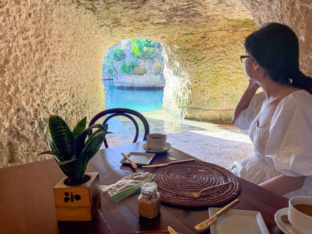 A table set in an alcove cut into the rock, the water bright through the opening