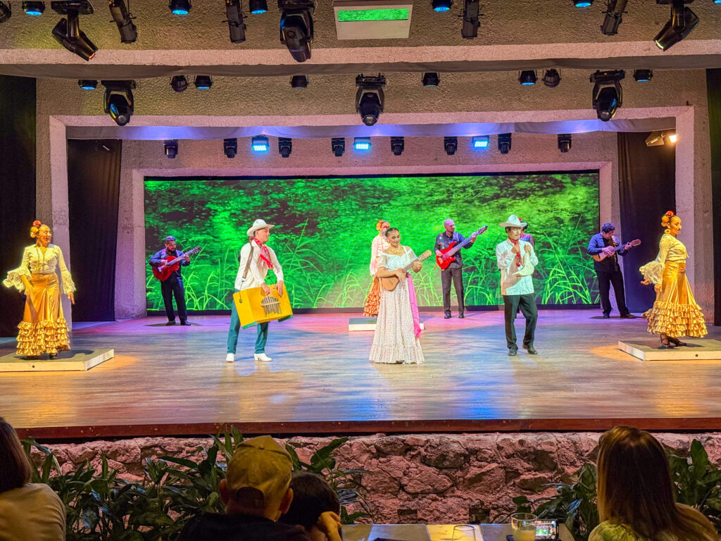 Dancers in traditional dress on a lit stage