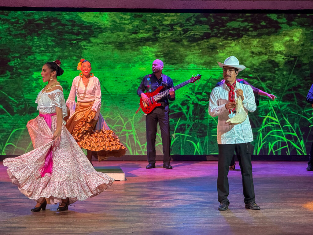 Musicians and dancers on a stage lit green