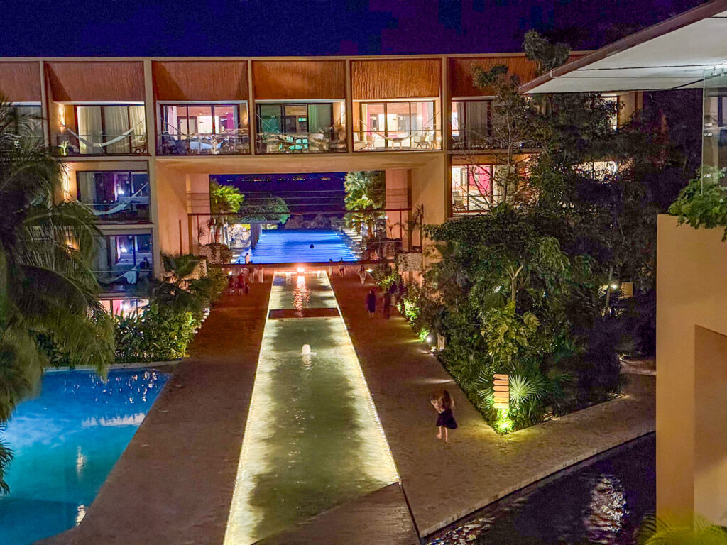 The lit interior along a long reflecting pool at night