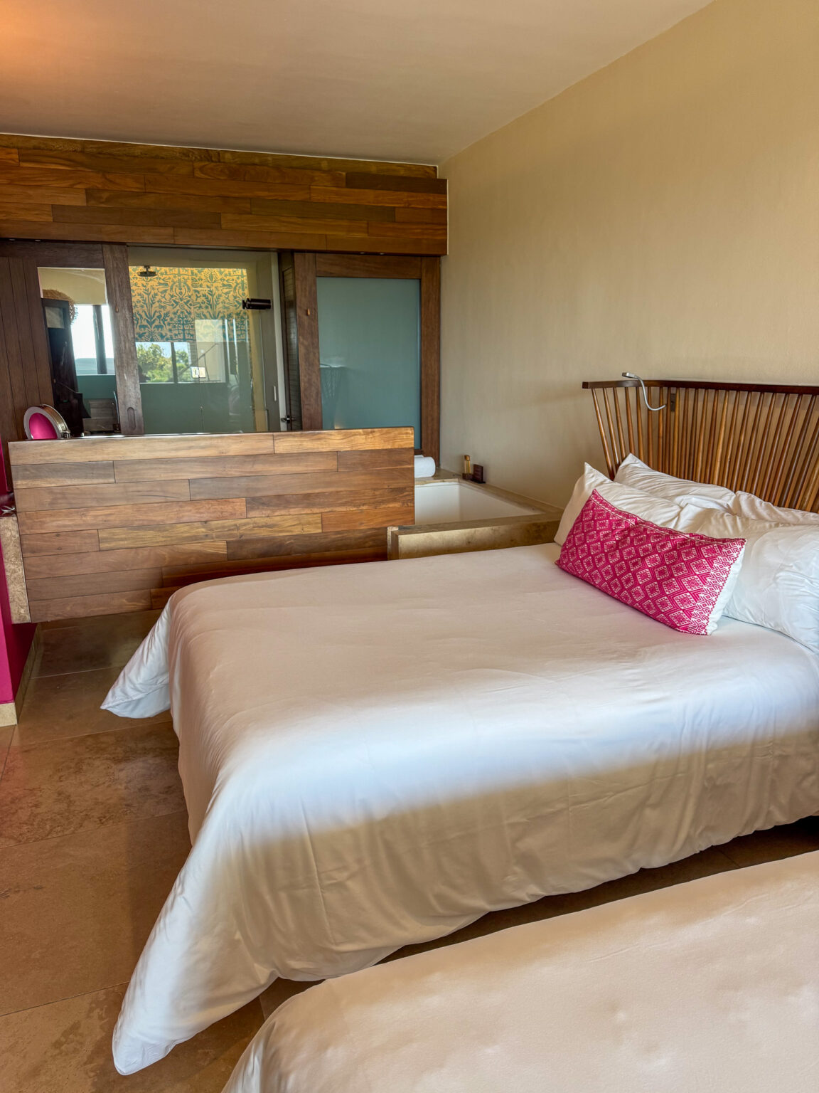 The bed set square to a wall of glass and the greenery outside