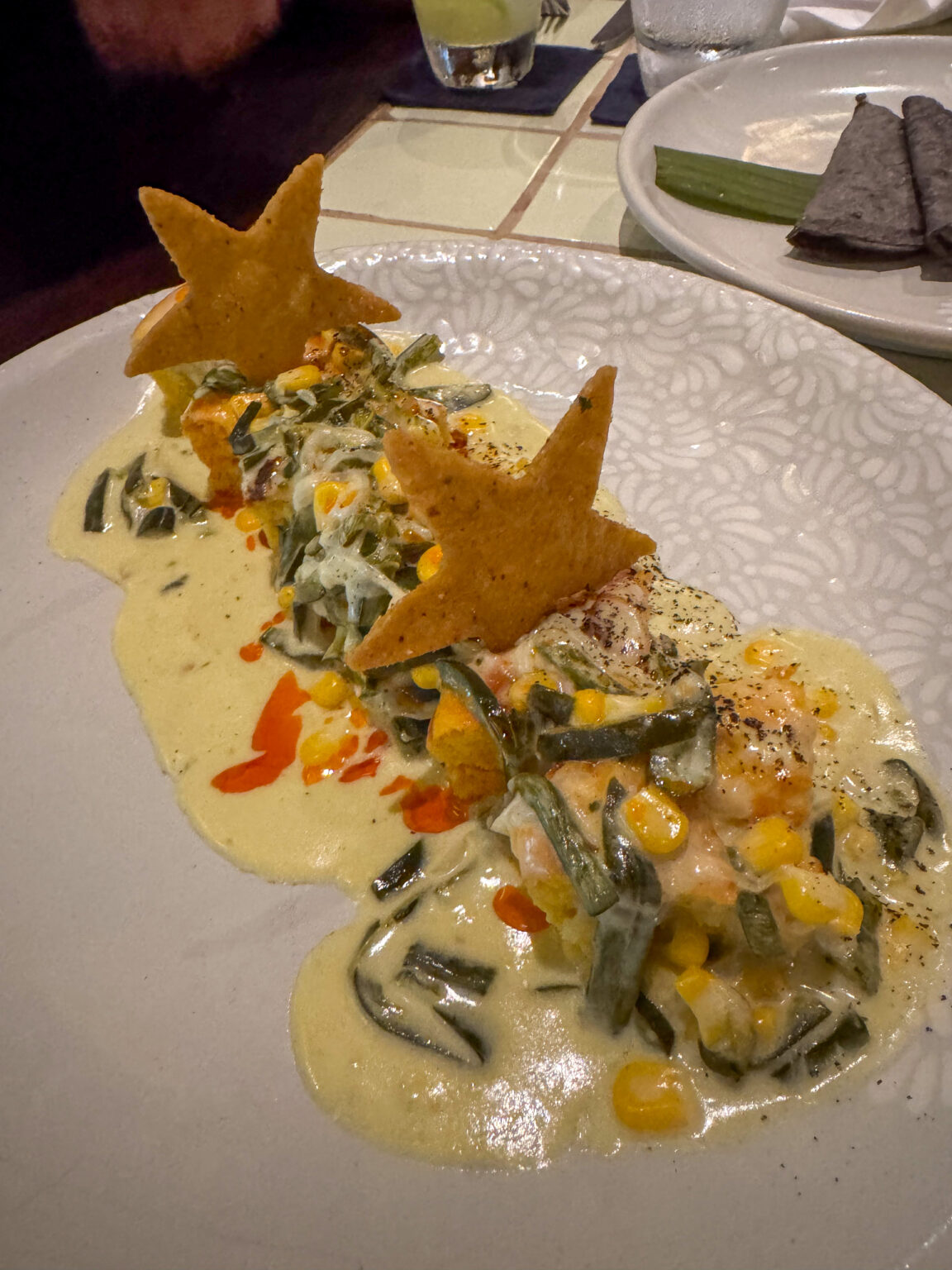 A dish plated on yellow sauce, the garnish cut into stars