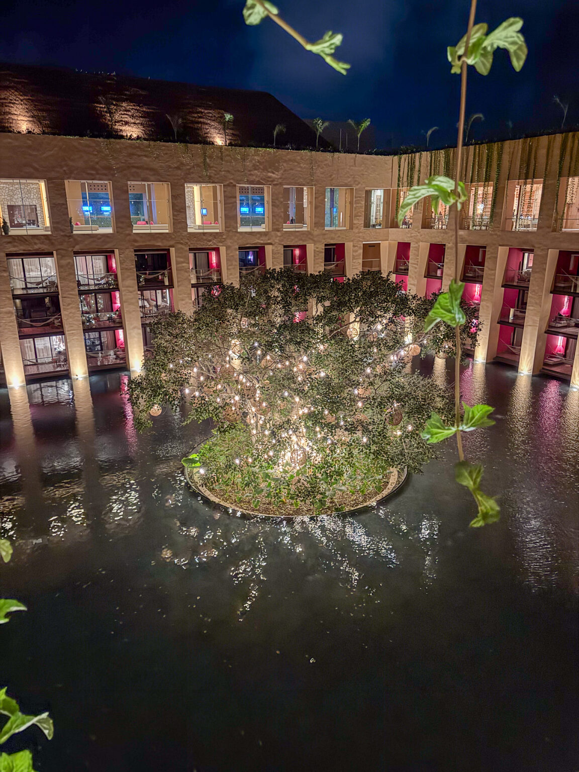 The pink building doubled in the still water at night