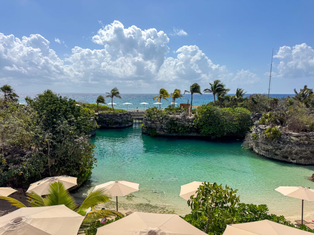 Umbrellas and loungers set along the edge of the green inlet